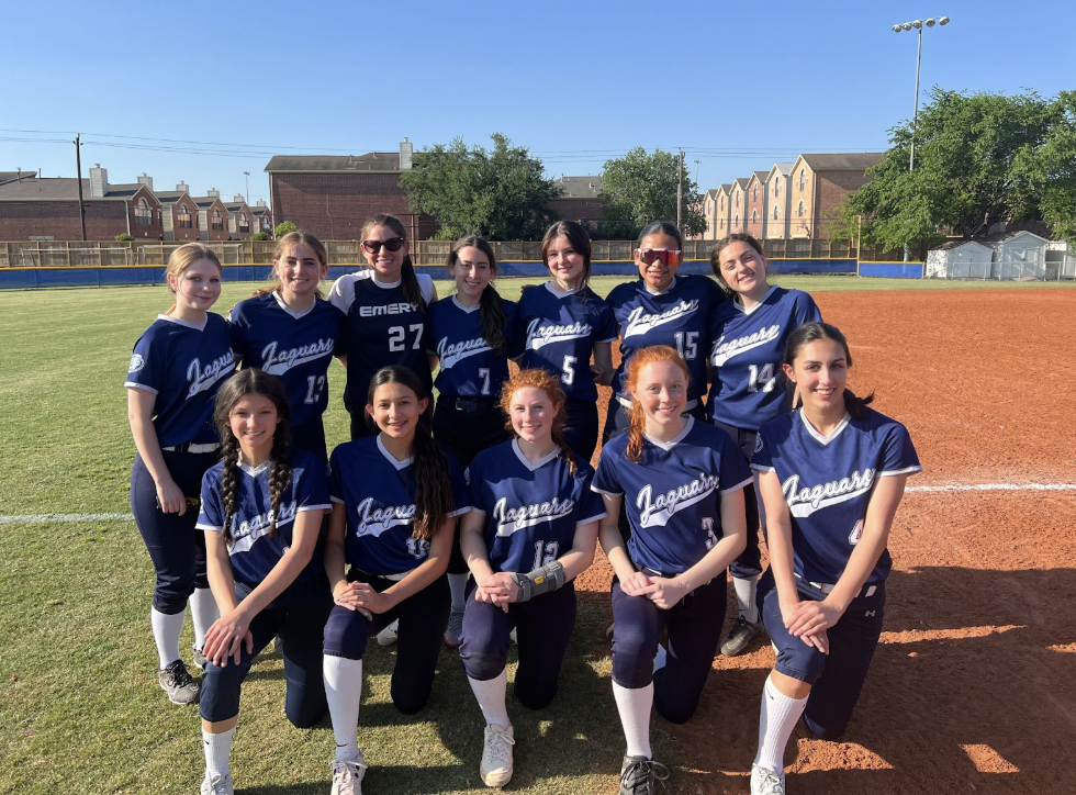 Emery’s upper school softball team smiles on the field.